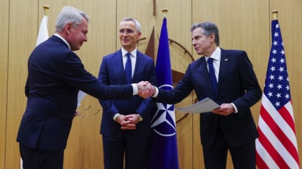 Nato Secretary-General Jens Stoltenberg smiles as Finnish Foreign Minister Pekka Haavisto and US Secretary of State Antony Blinken shake hands during a joining ceremony at the Nato foreign ministers' meeting at the Alliance's headquarters in Brussels, Belgium on 4 April 2023